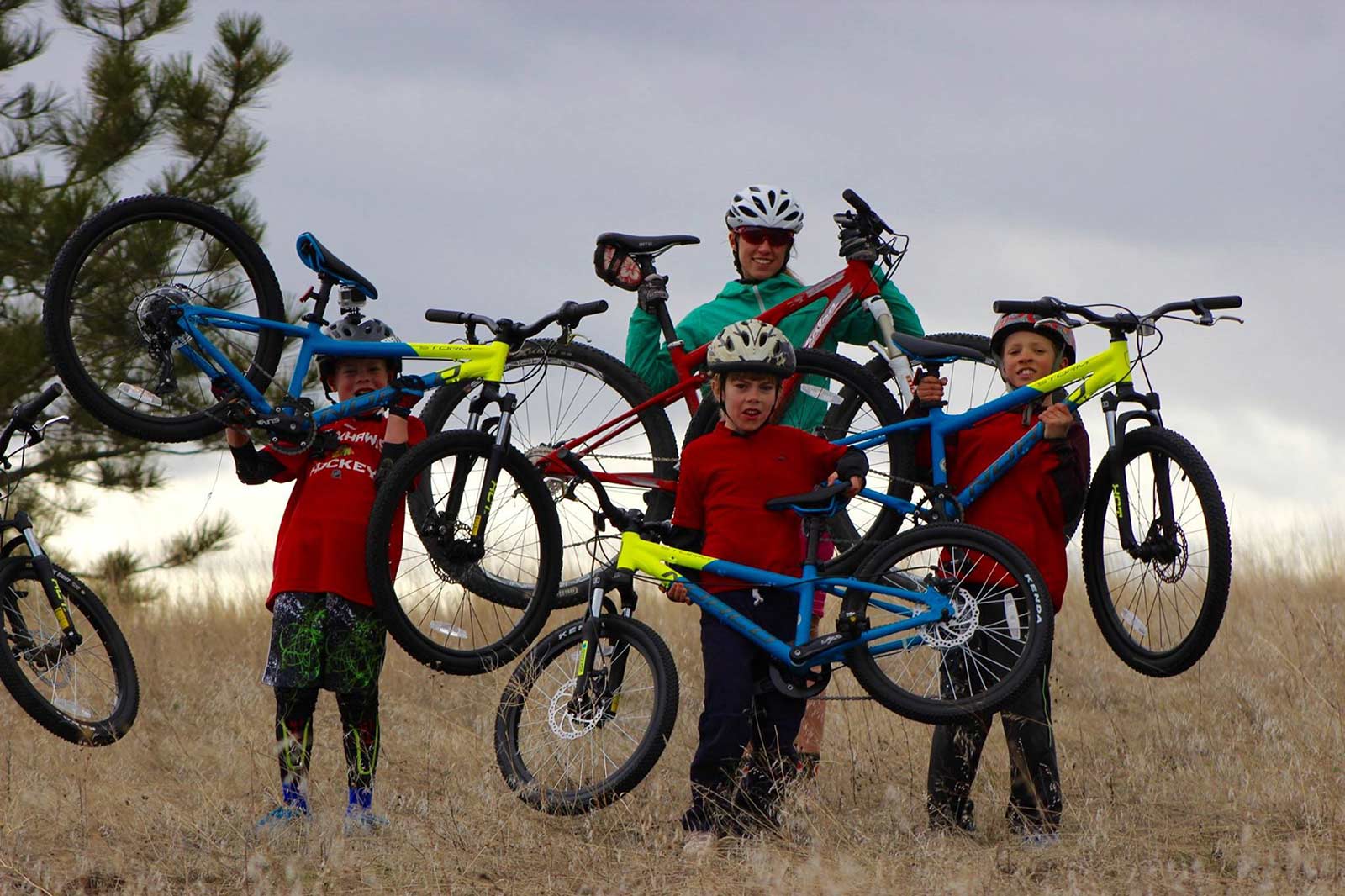 A family of cyclists raise their bikes on the Bitterroot Trail